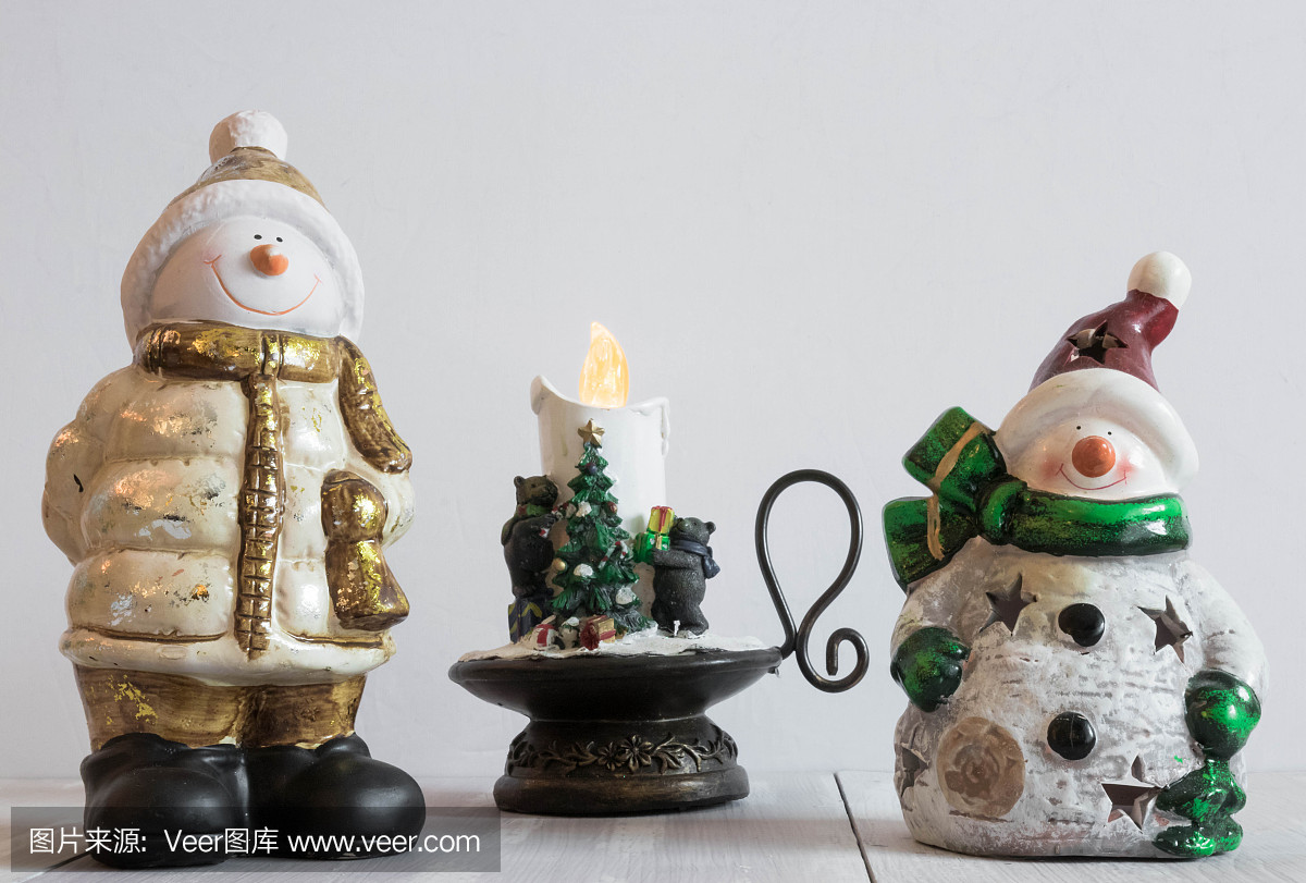 圣诞玩具雪人在灯光背景与装饰蜡烛。圣诞节水平组合。圣诞装饰品。元旦作文。明信片。